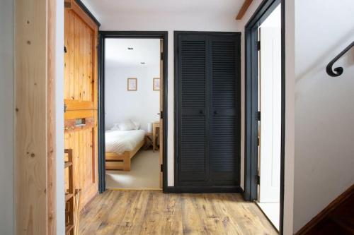 a hallway with a black door and a bedroom at 4 Bedroom Cottage with panoramic Harbour views in Falmouth