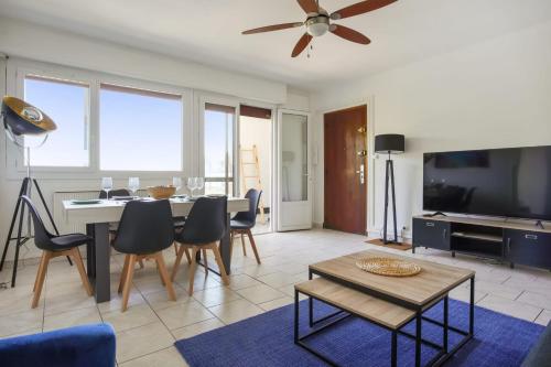 un soggiorno con tavolo, sedie e TV di Superb apartment with loggia and view on the sea - Hyères - Welkeys a Hyères