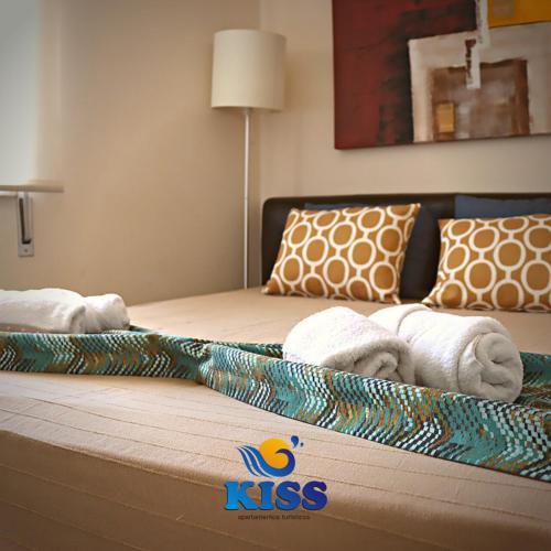 a hotel room with two beds with towels on them at Kiss - Apartamentos in Albufeira