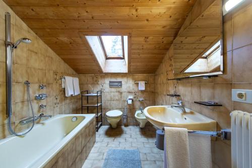 een badkamer met een bad, een wastafel en een toilet bij Panorama Apartment Pizaut in Ortisei
