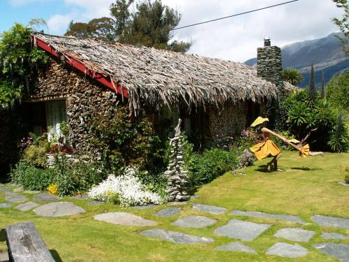 a house with a thatch roof and a yard at Little Paradise Lodge in Creighton