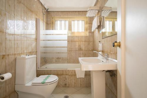 Hotel Alda Centro Gijón في خيخون: حمام مع مرحاض ومغسلة وحوض استحمام