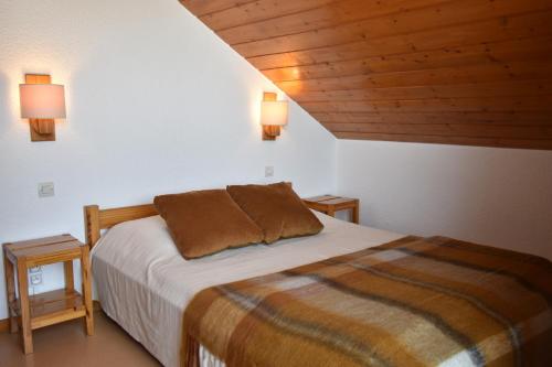 - une chambre avec un lit et deux lampes murales dans l'établissement VAUJANYLOCATIONS - COCHETTE II APT 17, à Vaujany