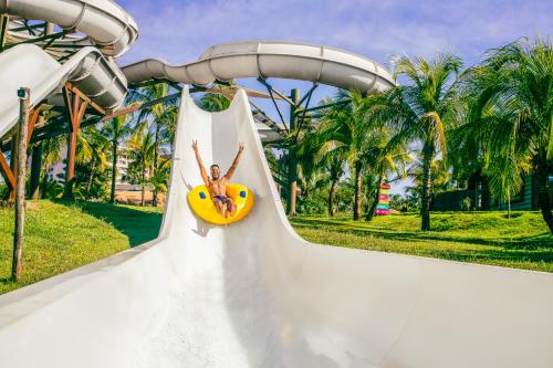 une femme utilisant un toboggan dans un parc aquatique dans l'établissement Hot Beach Resort, à Olímpia