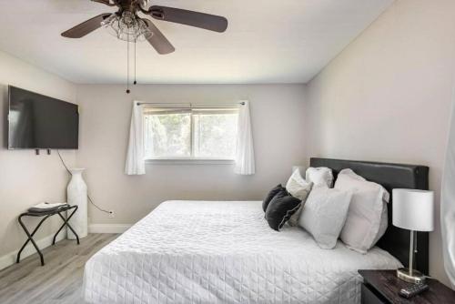 a bedroom with a white bed with a ceiling fan at 4 Bed 3 Bath House, Spacious, Smart TVs in all rooms, Whole house to yourself in Garland