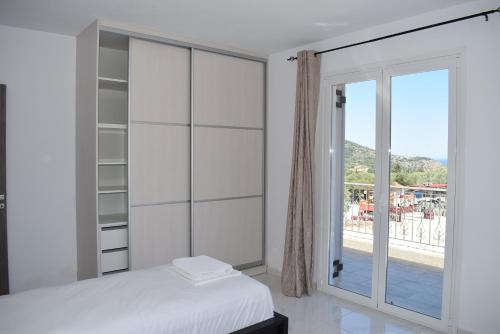 a bedroom with a bed and a sliding glass door at Black & White Apartments in Bekatoráta