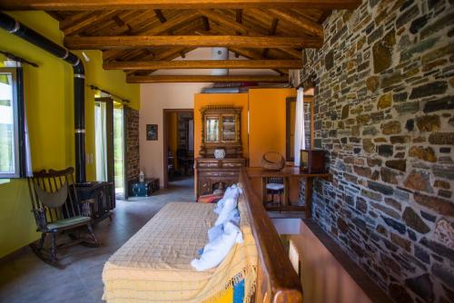 1 dormitorio con cama y pared de ladrillo en Iris' Traditional Stone House en Zárakes