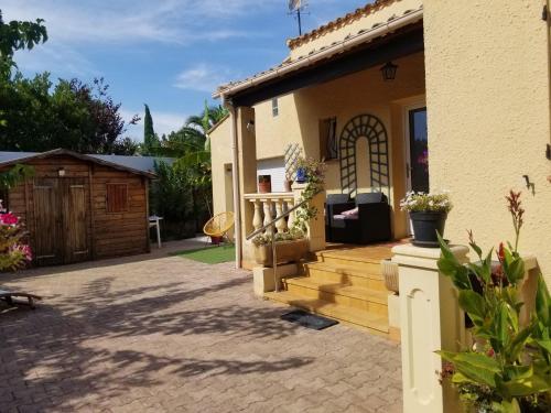 a house with a patio and a deck at Les Lauriers in Espondeilhan