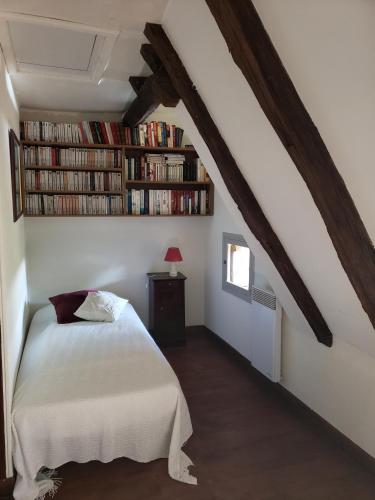 a bedroom with a bed and a book shelf with books at Villa La Cayrouse Piscine Tennis Boulodrome in Le Bouyssou