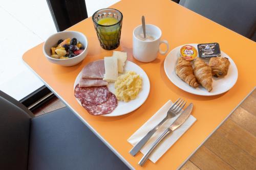 a table with two plates of food on it at Holiday Inn Express - Marseille Airport by IHG in Vitrolles