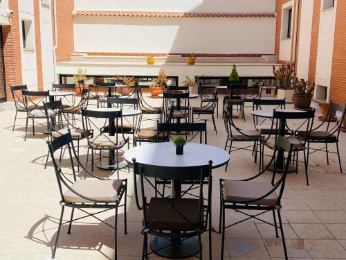 a group of tables and chairs in a courtyard at Hotel Equo Aranjuez in Aranjuez