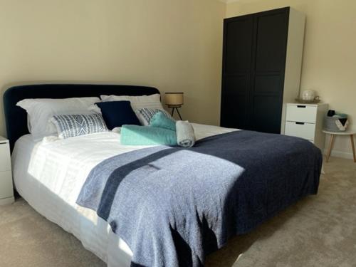 - une chambre avec un grand lit et une couverture bleue dans l'établissement Devonshire Bungalow - close to the Coast & Lakes., à Cleator
