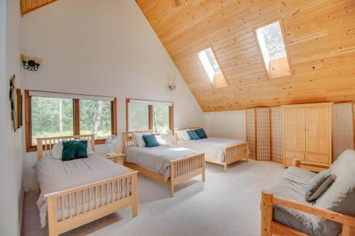 a bedroom with two beds and a wooden ceiling at Lakefront A-Frame Cabin, Year Round in Minong