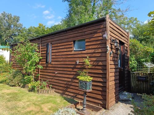 a wooden cabin with a window in a yard at Rivermead Holidays in Saint Breward