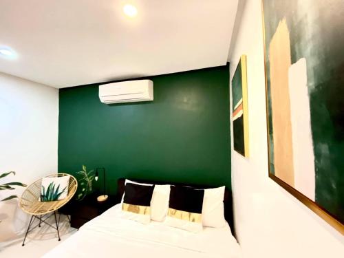 Un dormitorio con una pared de acento verde y una cama en Villa inspired with exclusive dipping pool, en Bacolod