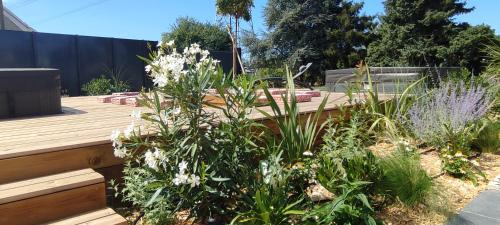a garden with white flowers and a wooden deck at Pomme de Reinette in Azay-le-Rideau