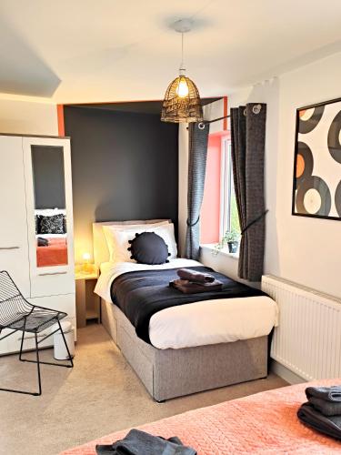 a bedroom with a bed with a black wall at Carvetii - Phoenix House - Near Hospital, max 8 ppl in Carlisle
