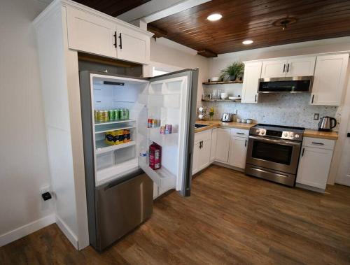 a kitchen with white cabinets and a stainless steel refrigerator at Shares View Luxury Apt in Rockledge