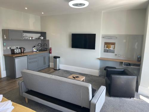 a living room with a couch and a table at Harmony Apartments in Weston-super-Mare