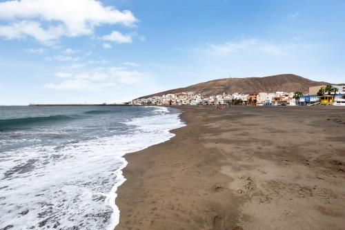 a beach with a town in the background at Holidays Maxorata Relax in Gran Tarajal