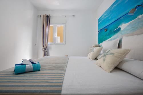 a bedroom with a large white bed with pillows at Holidays Maxorata Relax in Gran Tarajal