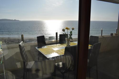 a dining room table with a view of the ocean at VIVE LA EXPERIENCIA, PLAYA, SPA, CASINO DE JUEGOS in Coquimbo