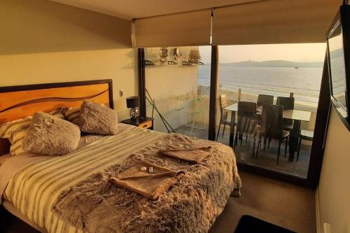 een slaapkamer met een bed en uitzicht op de oceaan bij VIVE LA EXPERIENCIA, PLAYA, SPA, CASINO DE JUEGOS in Coquimbo