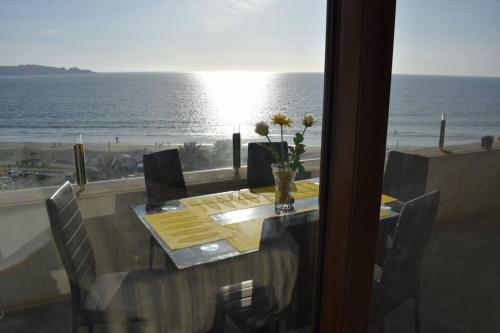 a dining table with a view of the ocean at VIVE LA EXPERIENCIA, PLAYA, SPA, CASINO DE JUEGOS in Coquimbo