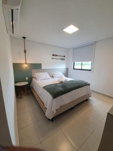 a bedroom with a bed and a table in it at Praia dos Carneiros Flat 206 C in Tamandaré
