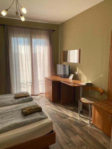 a bedroom with a bed and a desk with a computer at Kalcit Tourist Motel in Bélapátfalva