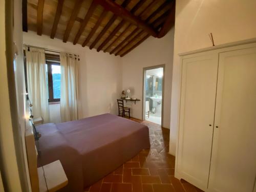 sypialnia z łóżkiem, stołem i oknem w obiekcie Agriturismo Podere Casella w mieście Castiglione dʼOrcia