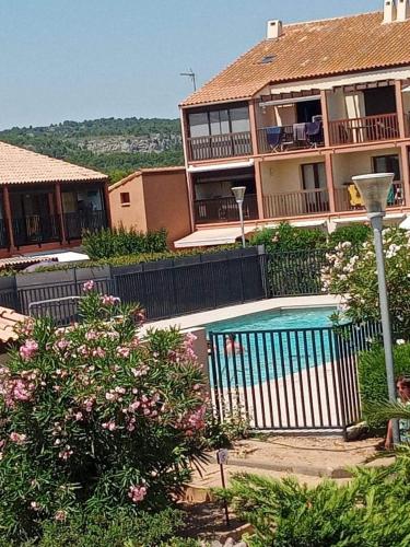 une maison avec une piscine devant une maison dans l'établissement résidence les amandines, à Gruissan