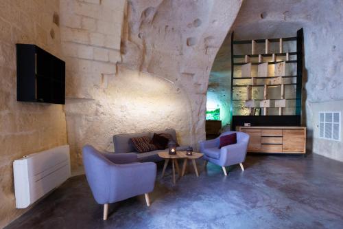 a living room with a couch and two chairs and a table at Grotta Barisano in Matera