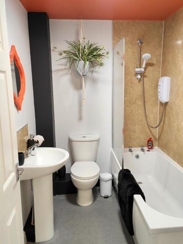 a bathroom with a toilet and a tub and a sink at Carvetii - Phoenix House - Near Hospital, max 8 ppl in Carlisle