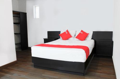 Un dormitorio con una cama con almohadas rojas. en OYO Hotel Plata,Fresnillo, Zacatecas, en Fresnillo de González Echeverría