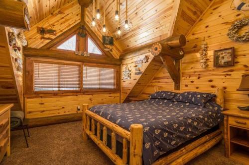 una camera con un letto in una baita di tronchi di Northwoods Log Cabin - 3 acre retreat! a Webb Lake