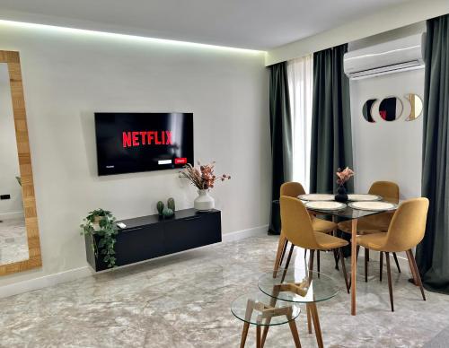 a living room with a table and chairs and a tv at Apartamento Lucano in Córdoba