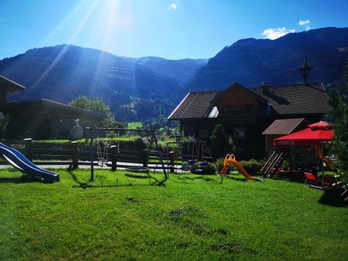 a playground in a yard with mountains in the background at Pension Schlager Taxerhof in Bad Hofgastein
