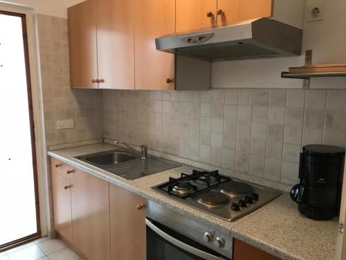 a kitchen with a sink and a stove top oven at Apartments Ruža Mikelić in Rab