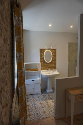 a bathroom with a sink and a mirror at Le Moulin de Moquesouris - Chambres d'hôtes et table d'hôte in Nazelles