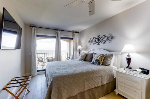 a bedroom with a bed and a balcony at Turtle Sea Dunes in Fernandina Beach