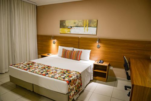 a hotel room with a bed and a television at Comfort Hotel Bauru in Bauru