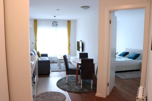 a living room with a table and a room with a couch at apartman Kami in Tuzla