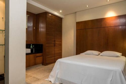 1 dormitorio con cama blanca y pared de madera en Perto de Ipanema, 250 metros da praia, entre postos 5 e 6, en Río de Janeiro