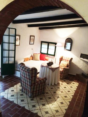a bedroom with a bed and two chairs and a table at Cortijo El Berrocal in Cazalla de la Sierra