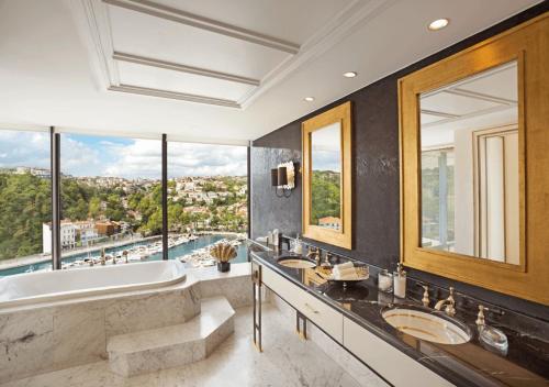 a bathroom with two sinks and a tub and a large window at The Grand Tarabya Managed by Accor in Istanbul