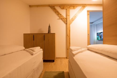 two beds in a room with a cross on the wall at ATTIC in Jahorina
