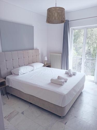 a bedroom with a large white bed with towels on it at Levante Breeze in Xirokástellon