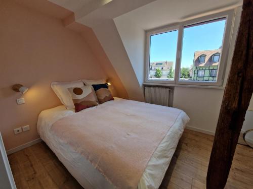 a small bedroom with a bed and a large window at Home La Petite Porte - Petite Venise - Colmar in Colmar
