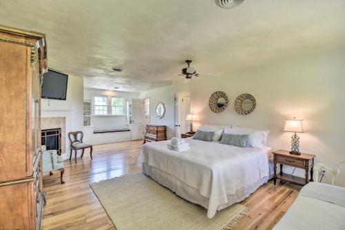 a bedroom with a white bed and a fireplace at Spacious Cheriton Home 8 Mi to Cape Charles! in Cape Charles